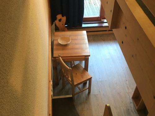 une table et une chaise en bois dans une chambre avec fenêtre dans l'établissement Duplex tranquille · Proche des pistes · Balcon · WiFi · Parking - FR-1-346-430, à Arc 1800