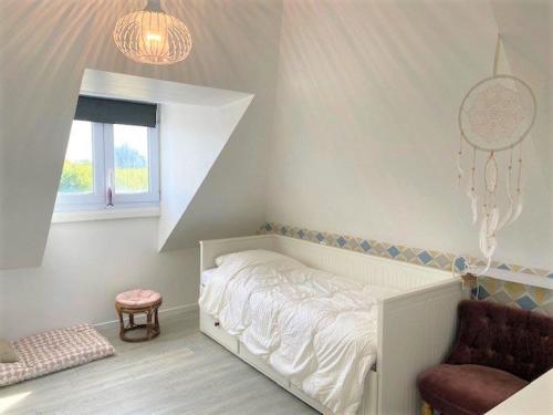 a small bedroom with a bed and a chair at Villa Quiberon, 5 pièces, 8 personnes - FR-1-478-205 in Quiberon