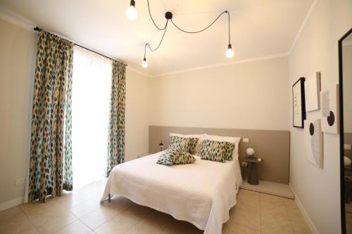 a bedroom with a white bed and a window at Casa Ercoli Abbadia in Abbadia di Montepulciano
