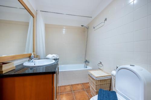 ein Badezimmer mit einem WC, einem Waschbecken und einer Badewanne in der Unterkunft IM On Casa do Navegador in Lagos