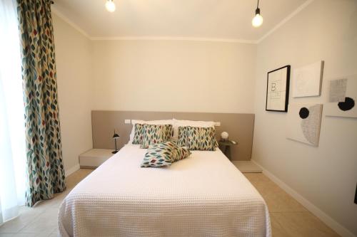 a bedroom with a large white bed with pillows at Casa Ercoli Abbadia in Abbadia di Montepulciano