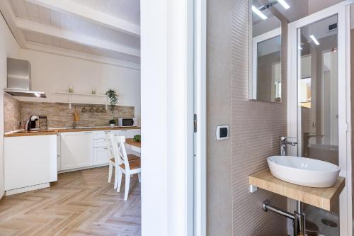ein Badezimmer mit einem Waschbecken und eine Küche mit weißen Schränken in der Unterkunft Casa Titina in Capoterra