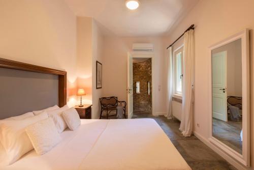 ein Schlafzimmer mit einem großen weißen Bett in einem Zimmer in der Unterkunft Sun-rock house by the sea in Ándros