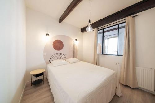 um quarto com uma cama branca e uma janela em LES ARCHES - BELLE DECORATION - WIFI - AC CLiM em Villeneuve-lès-Avignon