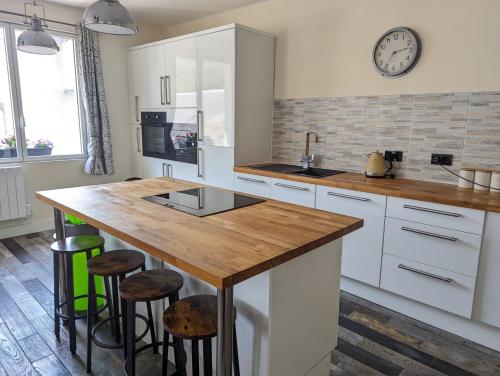 a kitchen with white cabinets and a wooden counter top at MSK65 Pyrenees Accommodation Sarrancolin in Sarrancolin