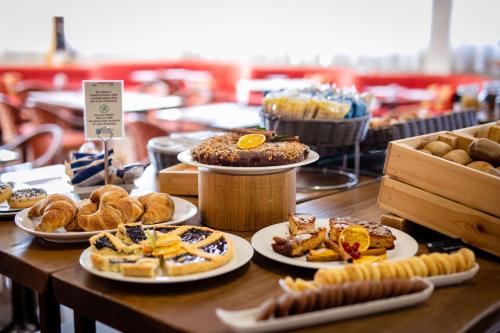 a table topped with plates of pastries and pastries at Etrusco Arezzo Hotel - Sure Hotel Collection by Best Western in Arezzo