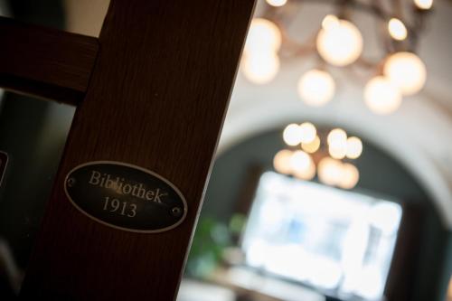a close up of a wooden pole with a clock on it at Hotel Schweizerhof Lenzerheide in Lenzerheide