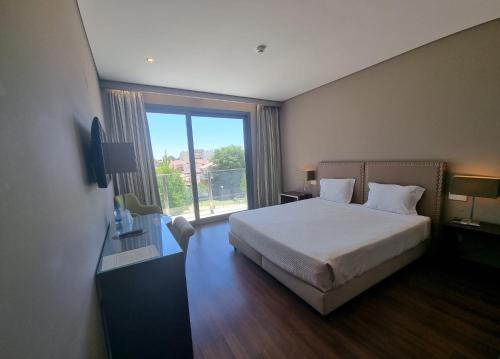 1 dormitorio con cama y ventana grande en Casa do Adro Hotel, en Ferreira do Zêzere