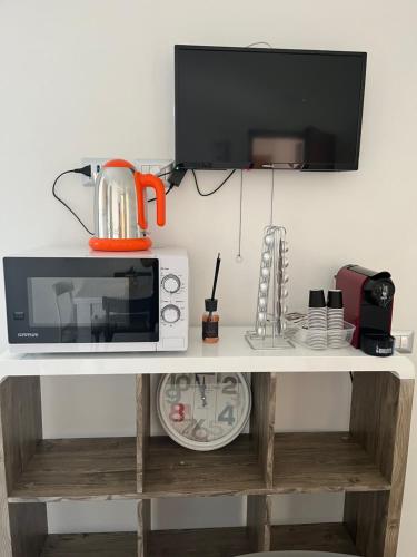 a microwave sitting on top of a white shelf at Le zagare in Palagiano