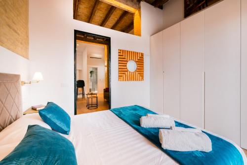 sypialnia z dużym łóżkiem z niebieskimi poduszkami w obiekcie Diseño Triana 2 rooms w Sewilli