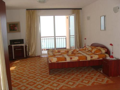 a bedroom with a bed and a large window at Villa Cvet Rooms in Ohrid