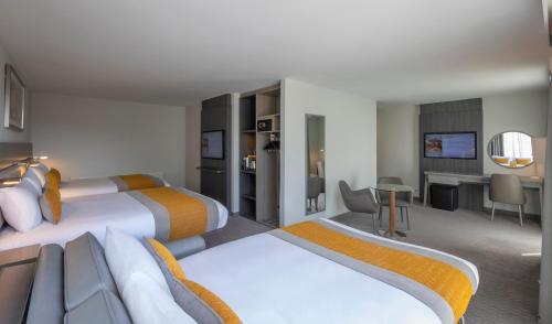 a hotel room with two beds and a desk at Maldron Hotel Smithfield Dublin City in Dublin