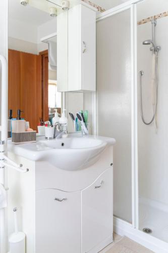 ein weißes Badezimmer mit Waschbecken und Dusche in der Unterkunft Cà dei Giani in Montagnaga