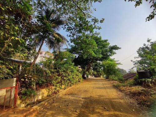 a dirt road with trees on the side of it at WhiteHouse Homestay by Oxystays Hospitality in Alibaug