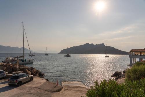 a car parked next to a body of water with boats at Absolute Perdika Aegina in Perdhika