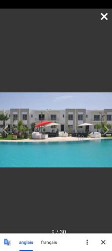 a screenshot of a picture of a building with a pool at Sidi Rahal Villa avec piscine à 5min de la plage in Dar Hamida