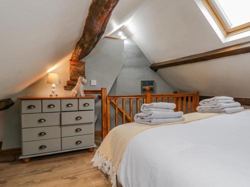 a attic bedroom with a bed and a dresser at Henrietta's Cottage in Guisborough