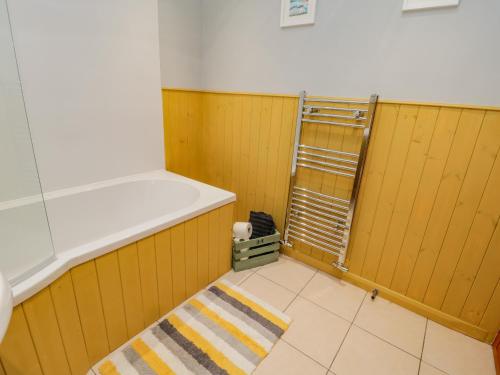 um quarto com paredes amarelas e um tapete num quarto em Henrietta's Cottage em Guisborough