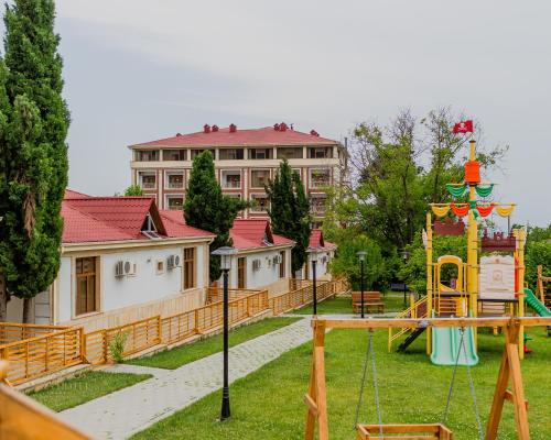 a playground in a park with a building at Afra Oghuz Mountain Resort Hotel in Oğuz
