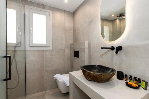 a bathroom with a sink and a mirror at SERAPIAS SUITES in Éxo Goniá