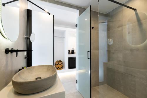 un bagno con un grande lavandino in pietra e una doccia di SERAPIAS SUITES a Éxo Goniá