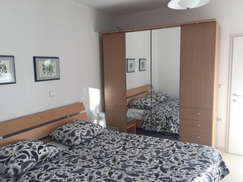 a bedroom with a bed and a large mirror at Apartman ENA in Ivan Dolac