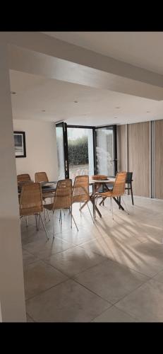 - une salle à manger avec des chaises, une table et des fenêtres dans l'établissement Grande maison familiale, Concarneau, à Trégunc