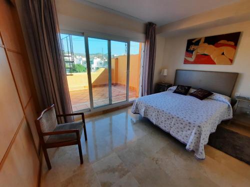 1 dormitorio con 1 cama, 1 silla y 1 ventana en Vivienda adosada con entrada independiente, en Marbella