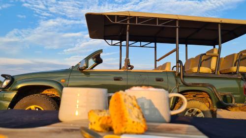 a green jeep parked in front of a table with food at Itaga Luxury Private Game Lodge in Bela-Bela