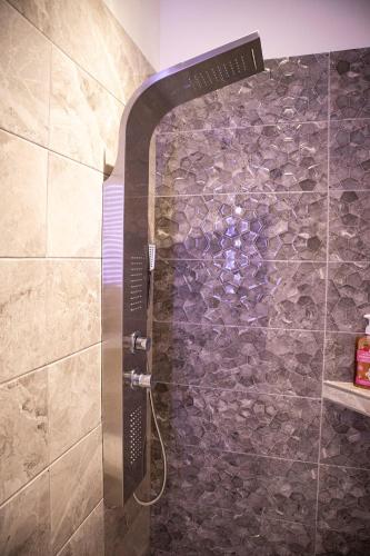 a shower in a bathroom with a stone wall at Rapsani Panorama Villa in Rapsáni
