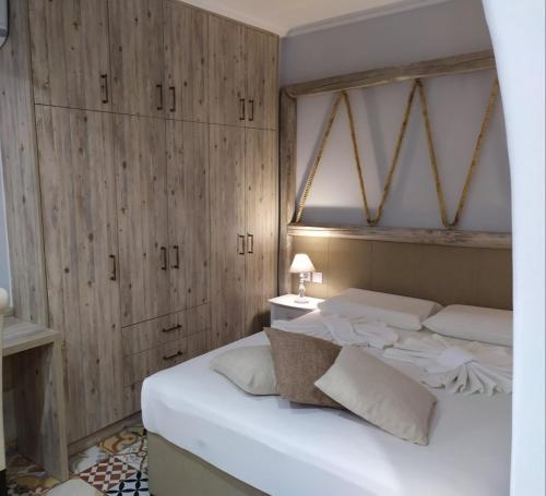 a bedroom with a large white bed with wooden walls at VILLA KALDERA in Skiathos Town