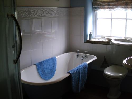 łazienka z wanną, toaletą i oknem w obiekcie Prospect Barn w mieście West Witton