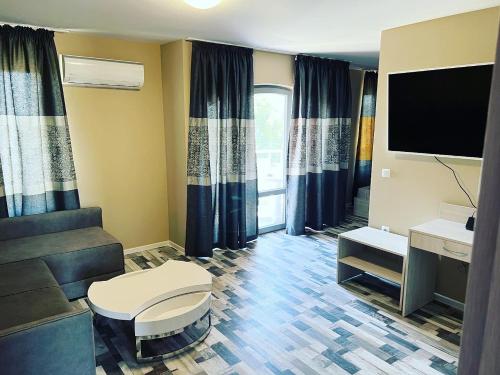a living room with a couch and a tv at Calisto Villas Arapya in Arapya