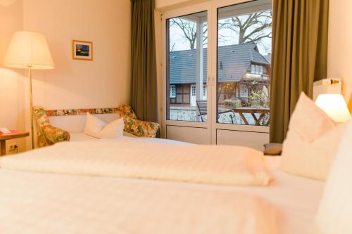 a hotel room with a bed and a window at Akzent Hotel Zur Grünen Eiche in Bispingen