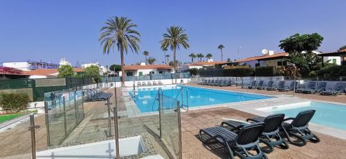 a swimming pool with lounge chairs in a resort at Casa Maga in Maspalomas