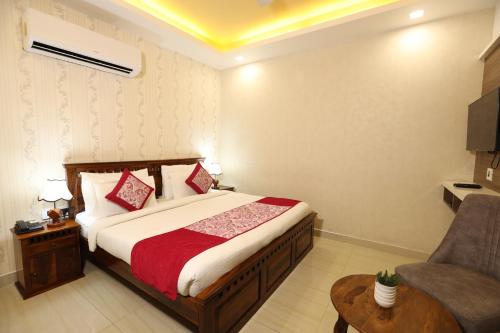 une chambre d'hôtel avec un lit et une chaise dans l'établissement Hotel Lavit Couple Friendly near Faridabad Metro station, à Faridabad