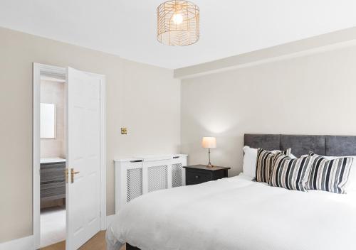 Un dormitorio blanco con una cama blanca y una lámpara en Stunning 2 bedroom apartment in fantastic location en Bristol