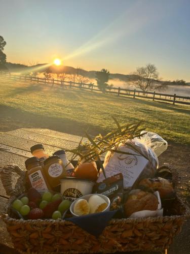 a basket filled with food on a field with the sunset at The Barracks, Tocal in Paterson