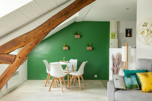 a living room with a green wall and a table and chairs at Le Marché Cosy à Vernon-Giverny - Claude Monet - Downtown in Vernon