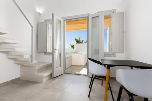 a room with a staircase and a table and chairs at SERAPIAS SUITES in Éxo Goniá