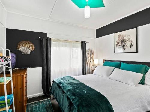 a bedroom with a large bed and a window at Coastal Vibes - Walk to beach, Marina, Cafes and Pubs in Shellharbour