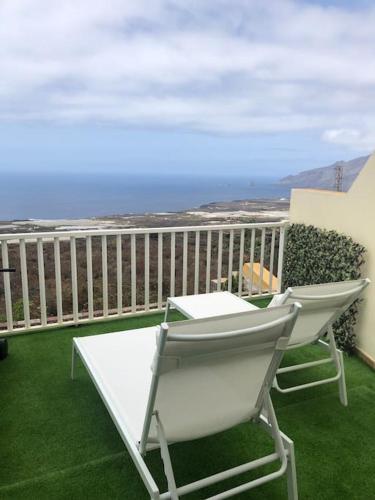 a white chair on a balcony with a view of the ocean at MIRADOR DE MERESE in Frontera