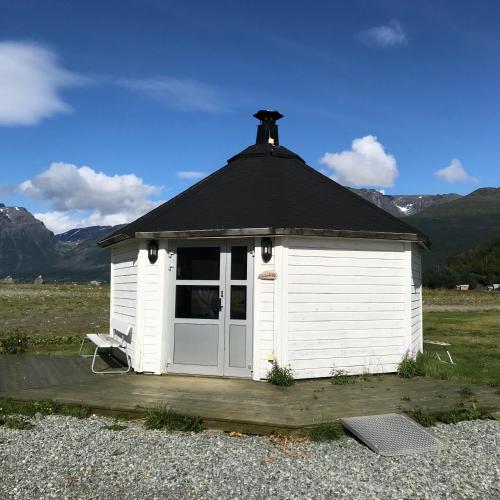 a small white building with a black roof at Løkvollstranda camping As in Samuelsberg