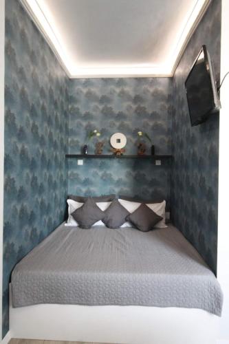 a bedroom with a bed with blue wallpaper at Viktória stúdióapartman in Győr