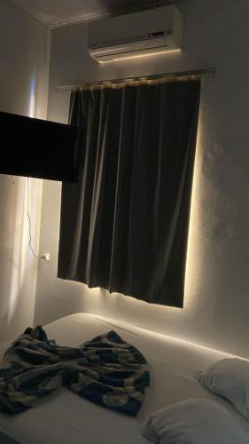 um cobertor deitado numa cama em frente a uma janela em HOTEL REAL em Marechal Cândido Rondon