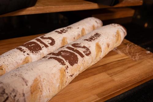 two burritos sitting on a wooden cutting board at ibis Betim in Betim