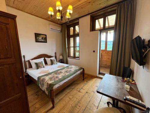 a bedroom with a bed and a table and window at Tsarevets Residence in Veliko Tŭrnovo