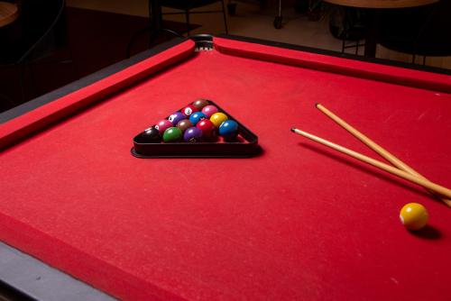 a red felt pool table with cue balls and chopsticks at ibis Betim in Betim