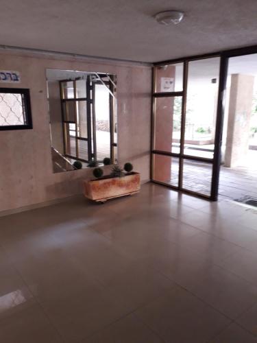 an empty room with a large mirror and a room with windows at Private room in the сomfortable apartment in Ashdod, 7 min walk to the beach in Ashdod