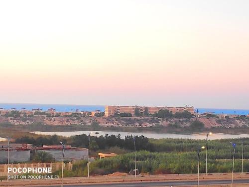 a view of a city and the ocean at sunset at Grand hills North Coast - Families Only z44 in Dawwār ‘Abd Allāh